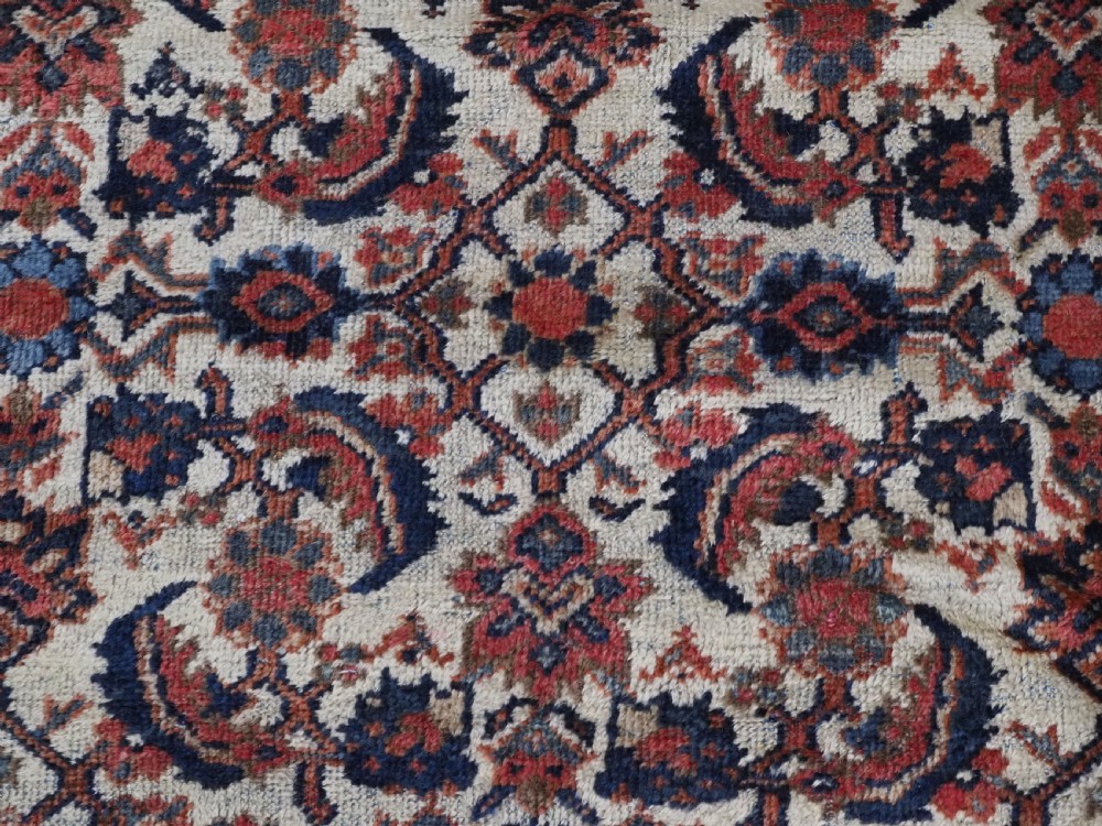 An antique hand-knotted Persian Mahal carpet featuring an ivory central field covered in geometric floral motifs surrounded by dark blue spandrels and a multi-banded border. View XI