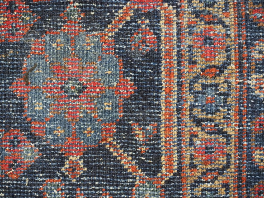 An antique hand-knotted Persian Mahal carpet featuring an ivory central field covered in geometric floral motifs surrounded by dark blue spandrels and a multi-banded border. View XVIII
