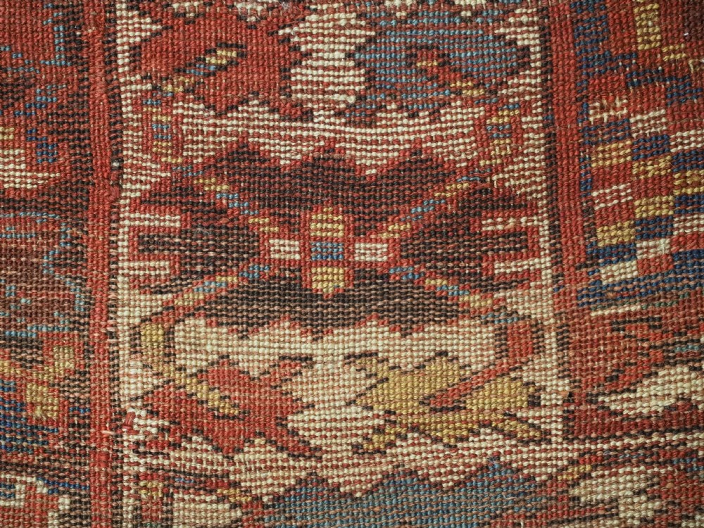 An antique hand-knotted Caucasian wool runner rug featuring a sequence of geometric diamond medallions on an indigo blue field surrounded by patterned borders. View XVII
