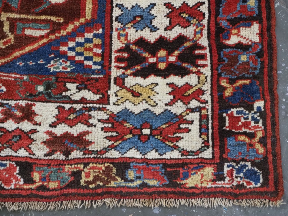 An antique hand-knotted Caucasian wool runner rug featuring a sequence of geometric diamond medallions on an indigo blue field surrounded by patterned borders. View XVIII