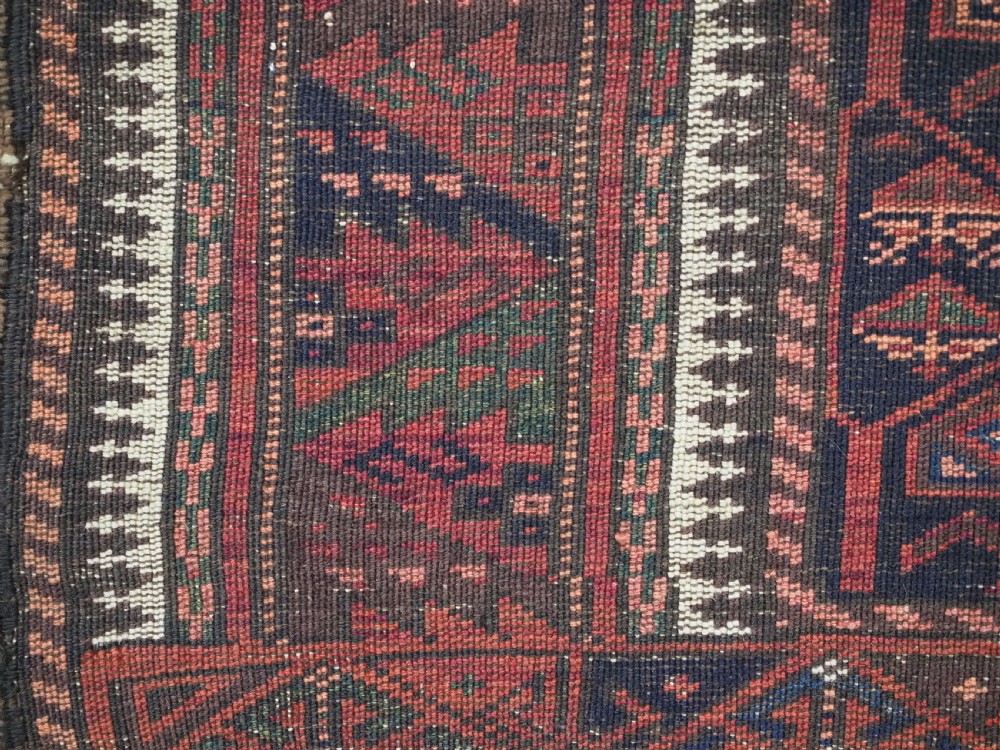 A hand-knotted wool prayer rug with a stepped mihrab niche, repeating geometric tree motifs, and a dark indigo blue and terracotta red palette. View XV