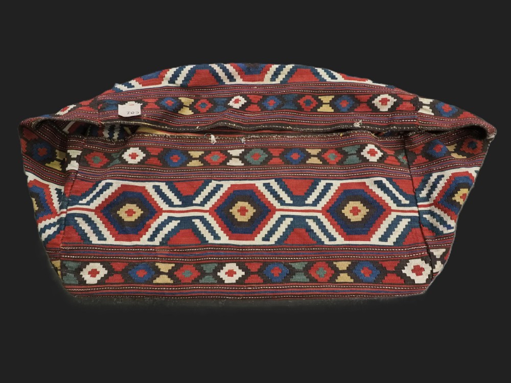 An antique hand-woven rectangular Caucasian mafrash storage bag decorated with red, blue, cream, and yellow geometric soumak patterns.
