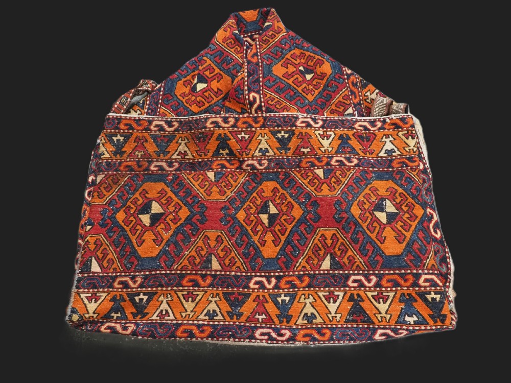 An antique South Caucasian mafrash storage bag featuring vibrant terracotta, navy blue, and cream geometric diamond patterns flat-woven in wool.