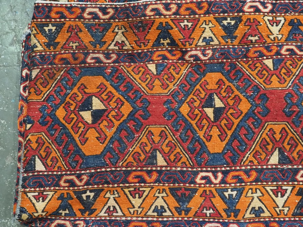 An antique South Caucasian mafrash storage bag featuring vibrant terracotta, navy blue, and cream geometric diamond patterns flat-woven in wool. View II