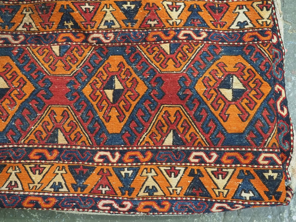 An antique South Caucasian mafrash storage bag featuring vibrant terracotta, navy blue, and cream geometric diamond patterns flat-woven in wool. View III