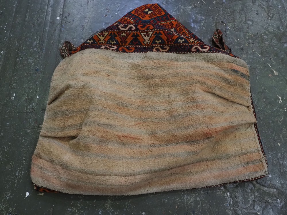 An antique South Caucasian mafrash storage bag featuring vibrant terracotta, navy blue, and cream geometric diamond patterns flat-woven in wool. View VI