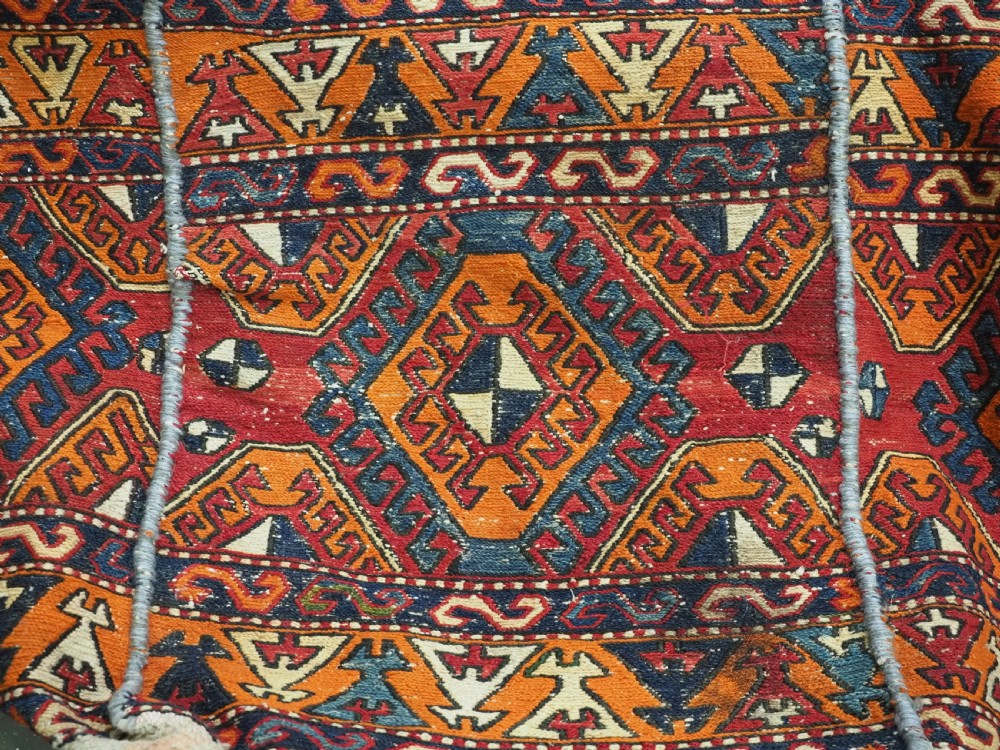 An antique South Caucasian mafrash storage bag featuring vibrant terracotta, navy blue, and cream geometric diamond patterns flat-woven in wool. View VIII