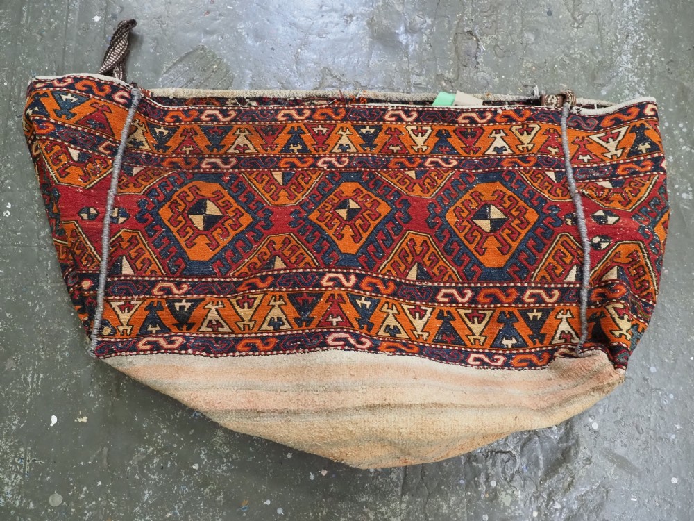 An antique South Caucasian mafrash storage bag featuring vibrant terracotta, navy blue, and cream geometric diamond patterns flat-woven in wool. View IX
