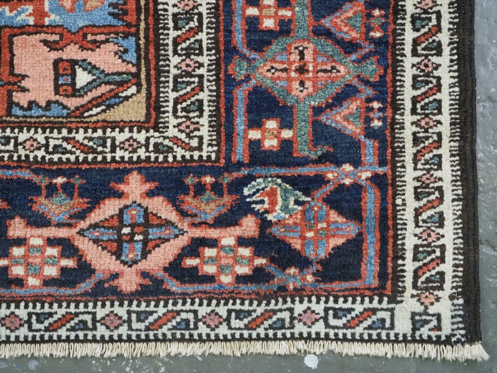 An antique hand-knotted Persian Heriz rug featuring a central starburst medallion in teal, terracotta, and cream on a patterned ground with a multi-band geometric border. View XVI