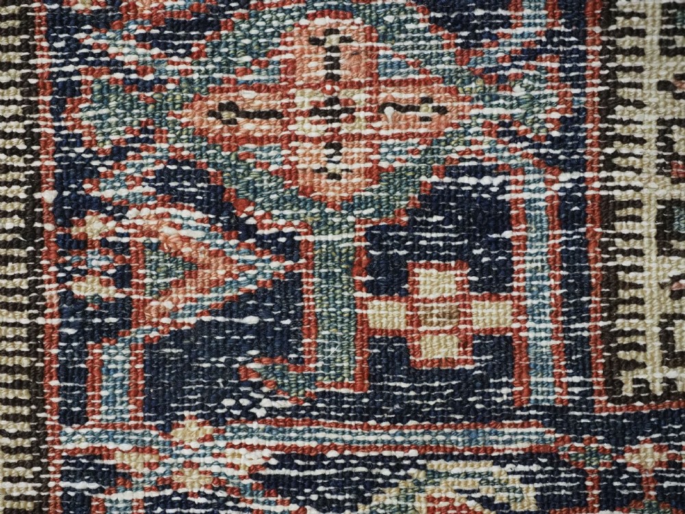 An antique hand-knotted Persian Heriz rug featuring a central starburst medallion in teal, terracotta, and cream on a patterned ground with a multi-band geometric border. View XVII