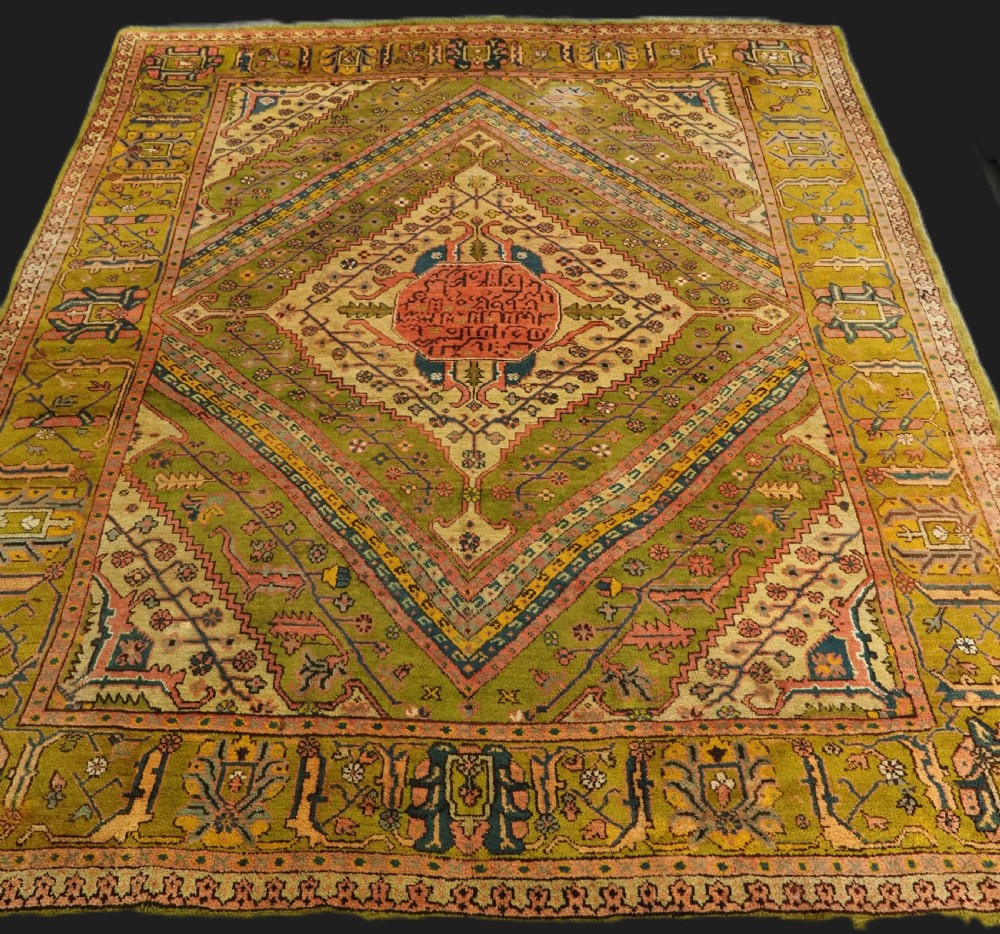 An antique Turkish Oushak wool carpet featuring an olive green field with a central cream and coral diamond medallion surrounded by detailed geometric borders. View II
