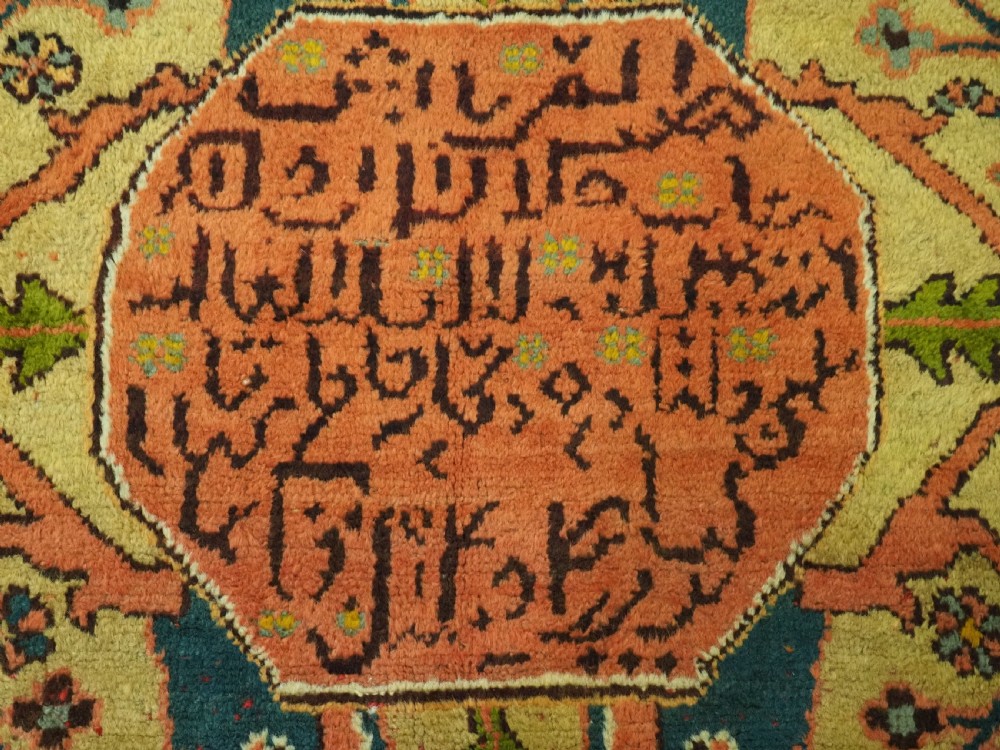 An antique Turkish Oushak wool carpet featuring an olive green field with a central cream and coral diamond medallion surrounded by detailed geometric borders. View XI
