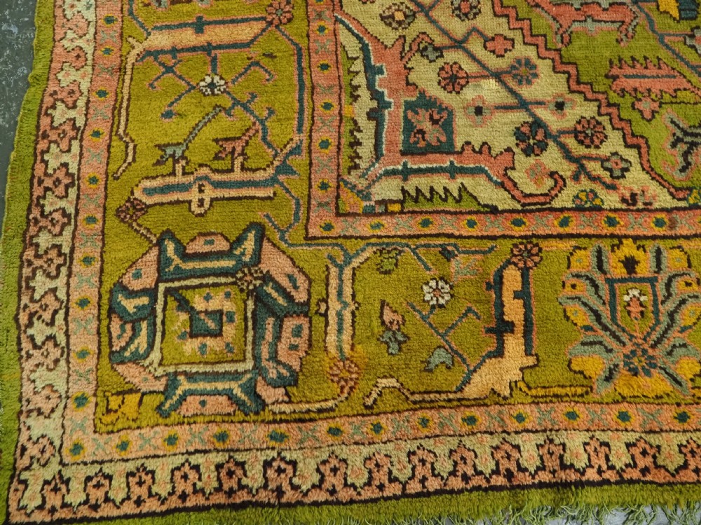 An antique Turkish Oushak wool carpet featuring an olive green field with a central cream and coral diamond medallion surrounded by detailed geometric borders. View XIV