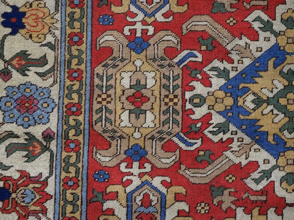 An antique hand-knotted wool rug with a central red field featuring geometric Karabagh blossom motifs and multi-tiered decorative borders. View XI