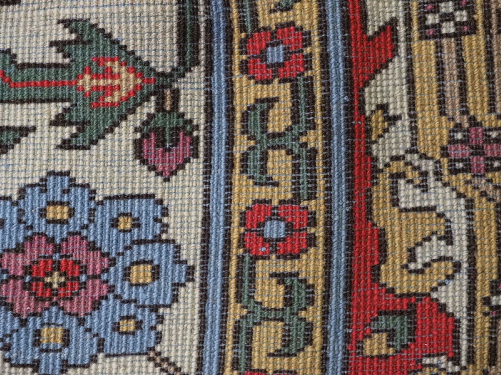 An antique hand-knotted wool rug with a central red field featuring geometric Karabagh blossom motifs and multi-tiered decorative borders. View XVI