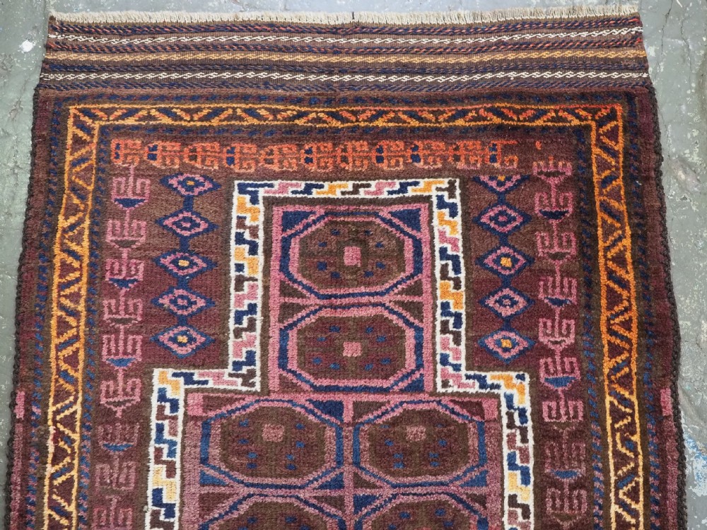 An antique hand-knotted Afghan Pashtun prayer rug featuring a dark brown background, stepped mihrab niche, geometric motifs in magenta and navy, and flat-woven kilim ends. View III