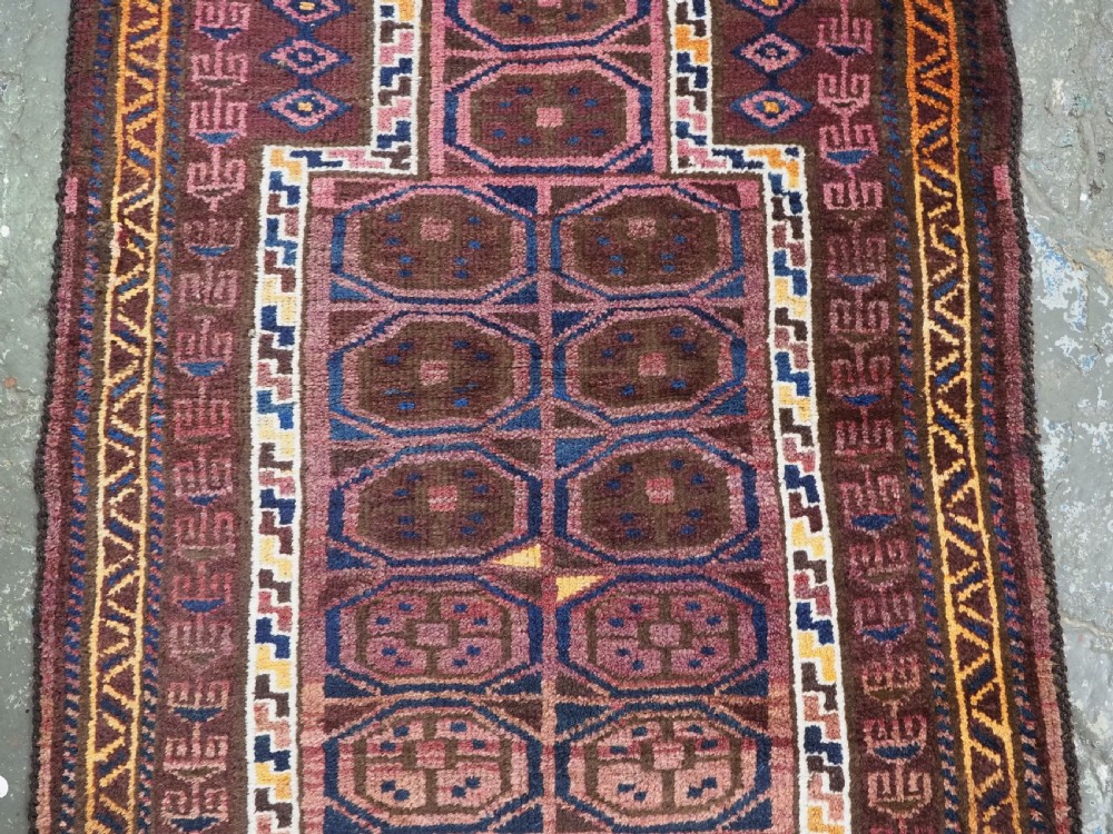 An antique hand-knotted Afghan Pashtun prayer rug featuring a dark brown background, stepped mihrab niche, geometric motifs in magenta and navy, and flat-woven kilim ends. View IV