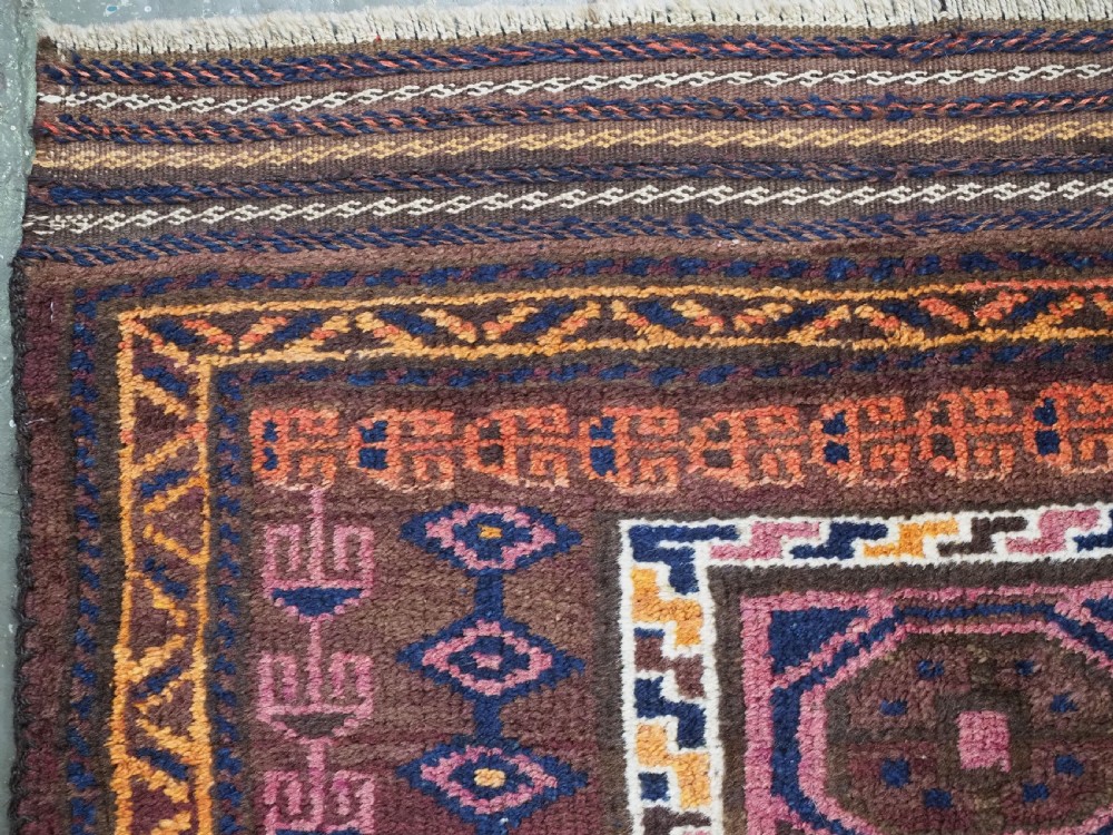 An antique hand-knotted Afghan Pashtun prayer rug featuring a dark brown background, stepped mihrab niche, geometric motifs in magenta and navy, and flat-woven kilim ends. View VI