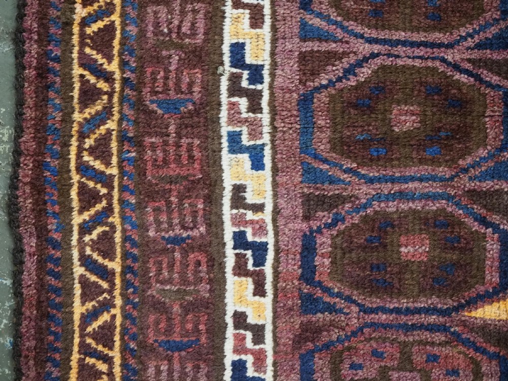An antique hand-knotted Afghan Pashtun prayer rug featuring a dark brown background, stepped mihrab niche, geometric motifs in magenta and navy, and flat-woven kilim ends. View VII