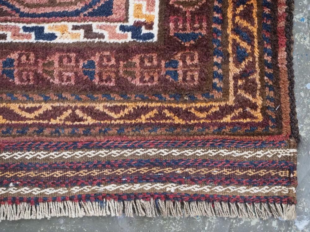 An antique hand-knotted Afghan Pashtun prayer rug featuring a dark brown background, stepped mihrab niche, geometric motifs in magenta and navy, and flat-woven kilim ends. View X