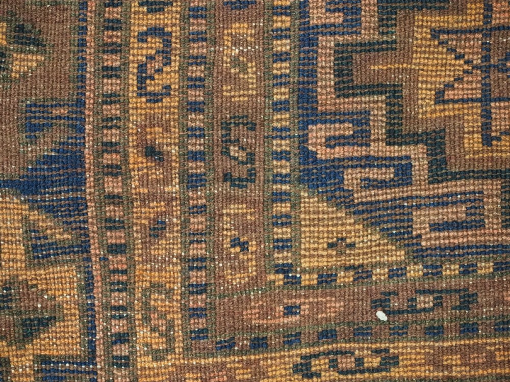 An antique Kurdish Kordi hand-knotted wool rug decorated with repeating octagonal Memlinc guls in navy blue, terracotta, and ochre. View XII