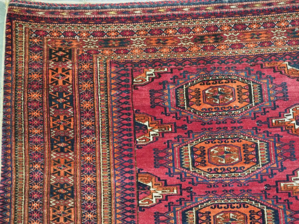 An antique crimson red wool Tekke Turkmen chuval featuring nine central octagonal gul motifs and a plain weave back. View VI