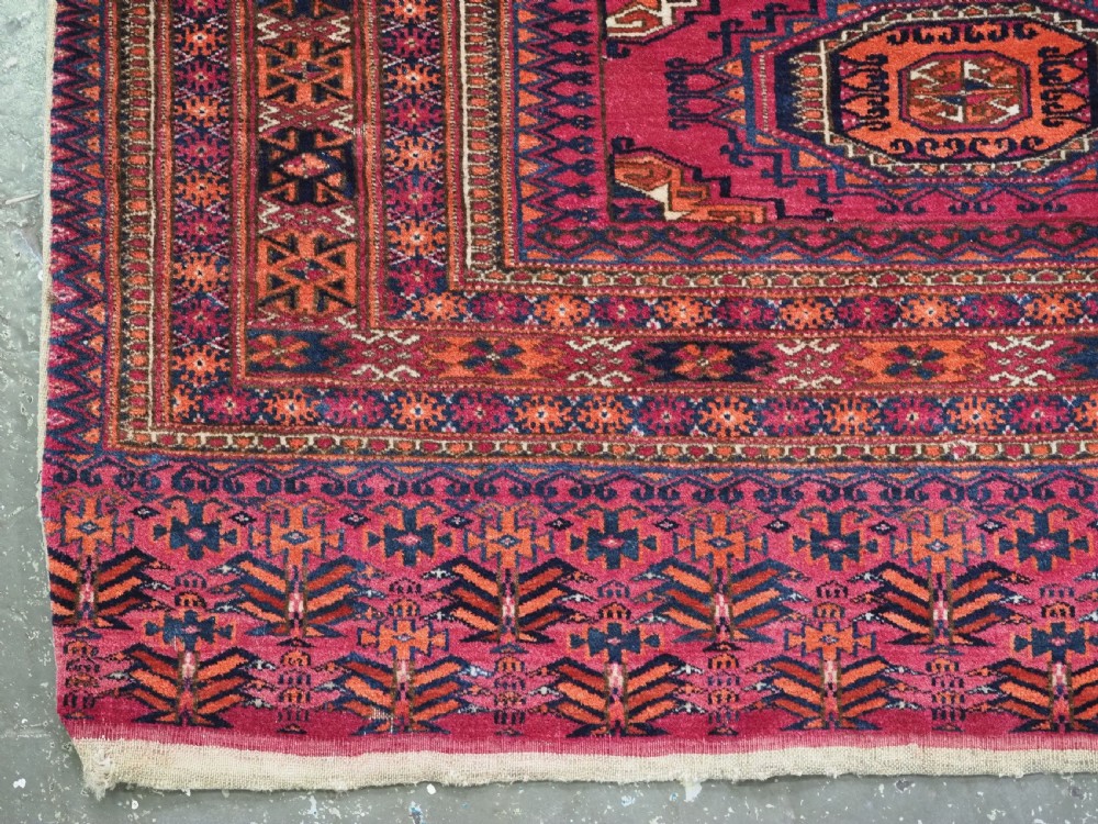 An antique crimson red wool Tekke Turkmen chuval featuring nine central octagonal gul motifs and a plain weave back. View VII