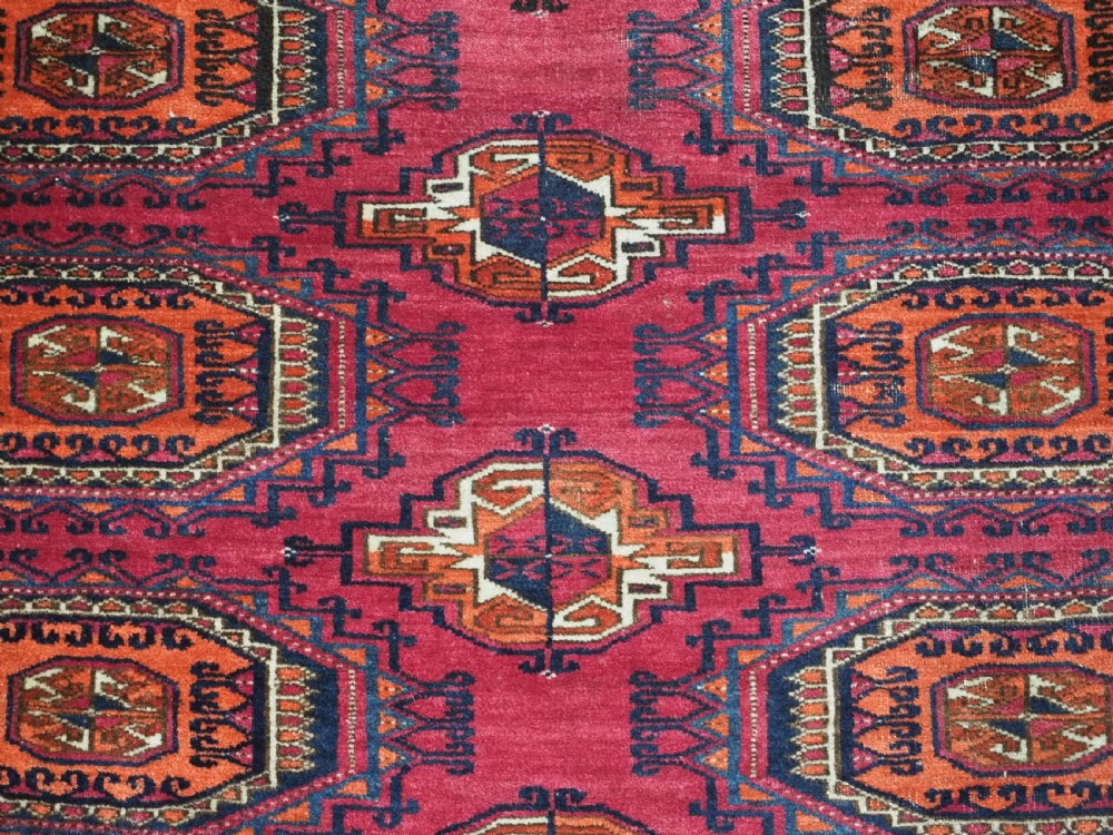 An antique crimson red wool Tekke Turkmen chuval featuring nine central octagonal gul motifs and a plain weave back. View VIII
