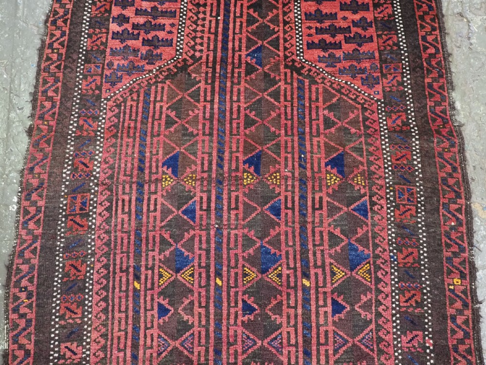 An antique Afghan wool prayer rug displaying a dark brown field with geometric lattice patterns framed by a terracotta arch motif. View IV