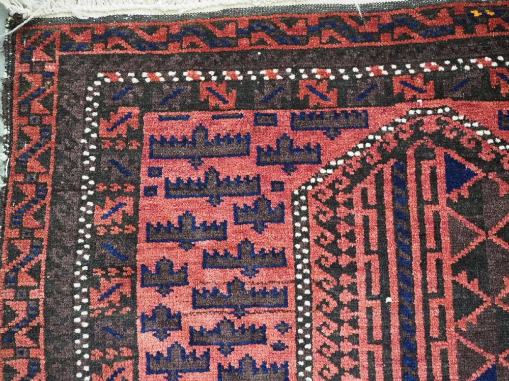 An antique Afghan wool prayer rug displaying a dark brown field with geometric lattice patterns framed by a terracotta arch motif. View VI