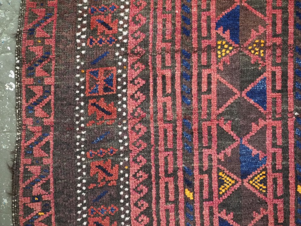 An antique Afghan wool prayer rug displaying a dark brown field with geometric lattice patterns framed by a terracotta arch motif. View VII