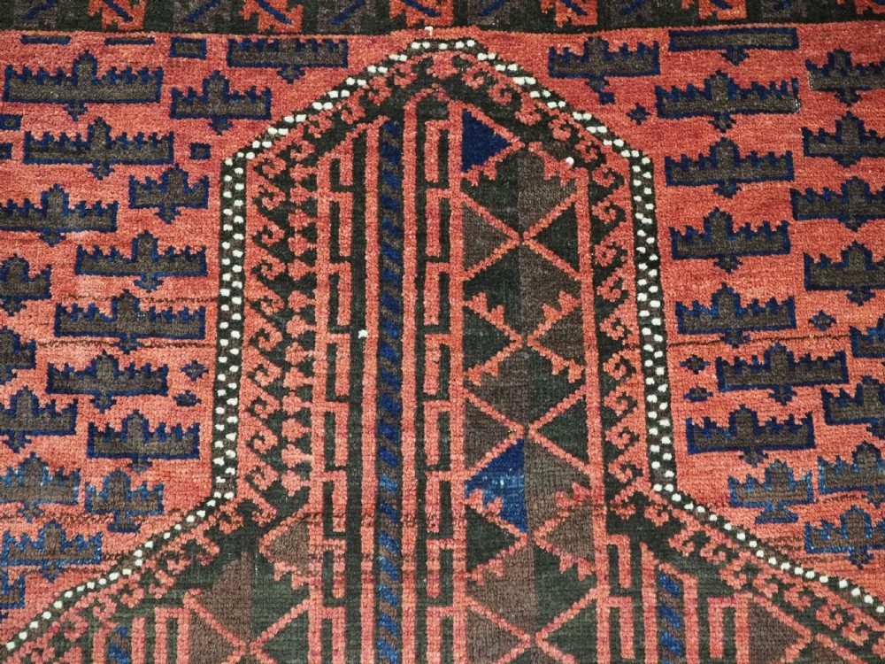 An antique Afghan wool prayer rug displaying a dark brown field with geometric lattice patterns framed by a terracotta arch motif. View VIII