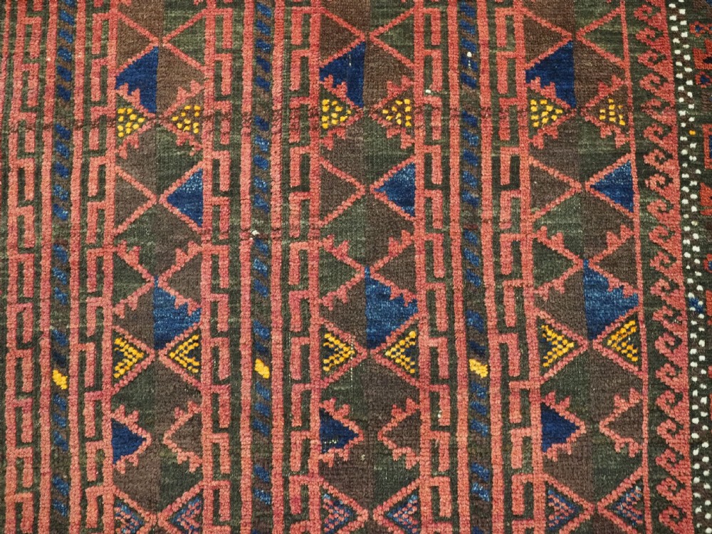 An antique Afghan wool prayer rug displaying a dark brown field with geometric lattice patterns framed by a terracotta arch motif. View IX