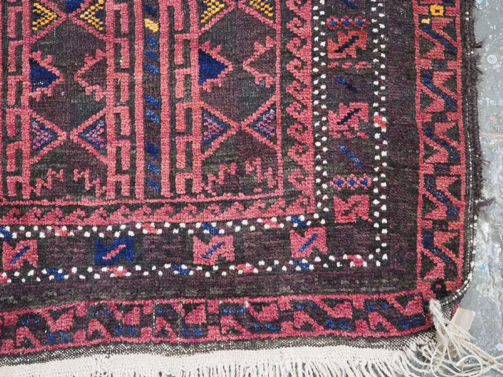 An antique Afghan wool prayer rug displaying a dark brown field with geometric lattice patterns framed by a terracotta arch motif. View X