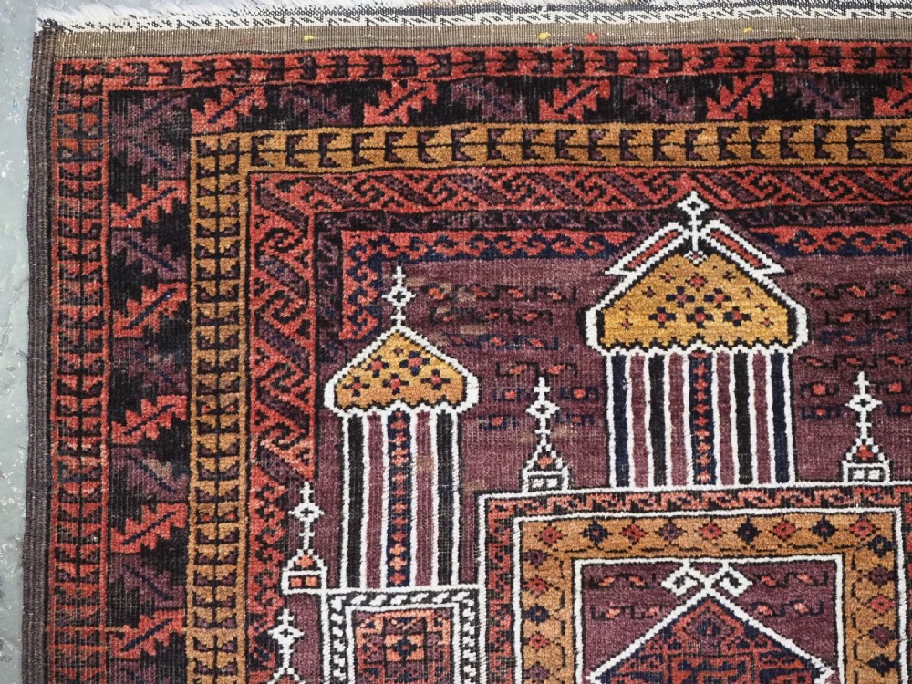 An antique hand-knotted Afghan Baluch wool prayer rug featuring a triple mihrab architectural design in burgundy, brown, ochre, and white tones. View VI