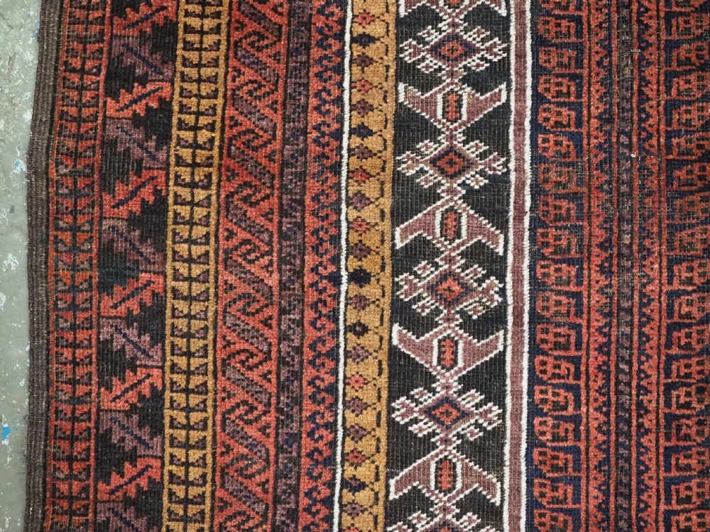 An antique hand-knotted Afghan Baluch wool prayer rug featuring a triple mihrab architectural design in burgundy, brown, ochre, and white tones. View VII