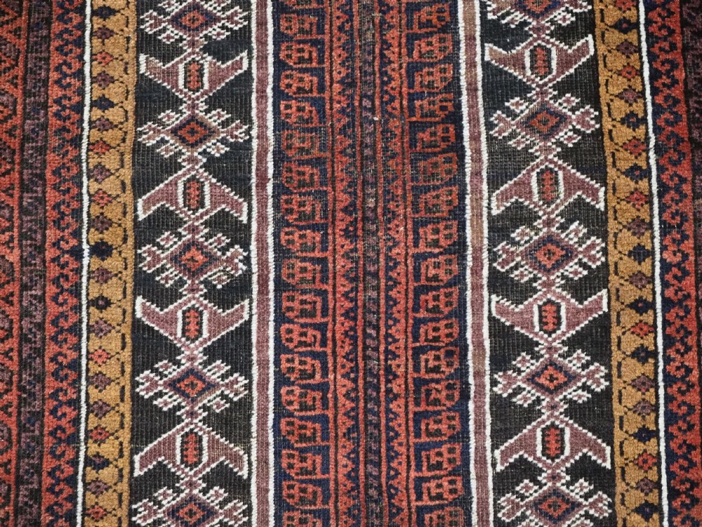 An antique hand-knotted Afghan Baluch wool prayer rug featuring a triple mihrab architectural design in burgundy, brown, ochre, and white tones. View IX