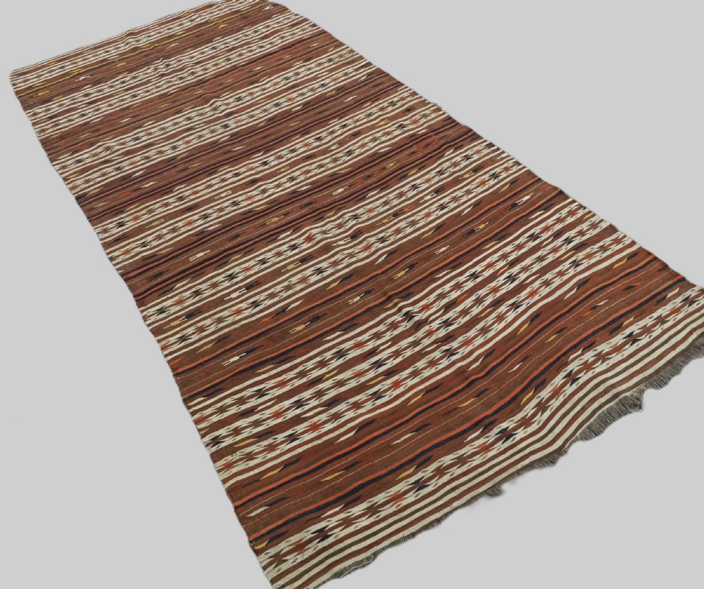 An antique flatweave Turkmen Dali wool kilim rug featuring horizontal bands of terracotta brown, cream, ochre, and dark navy geometric patterns. View II