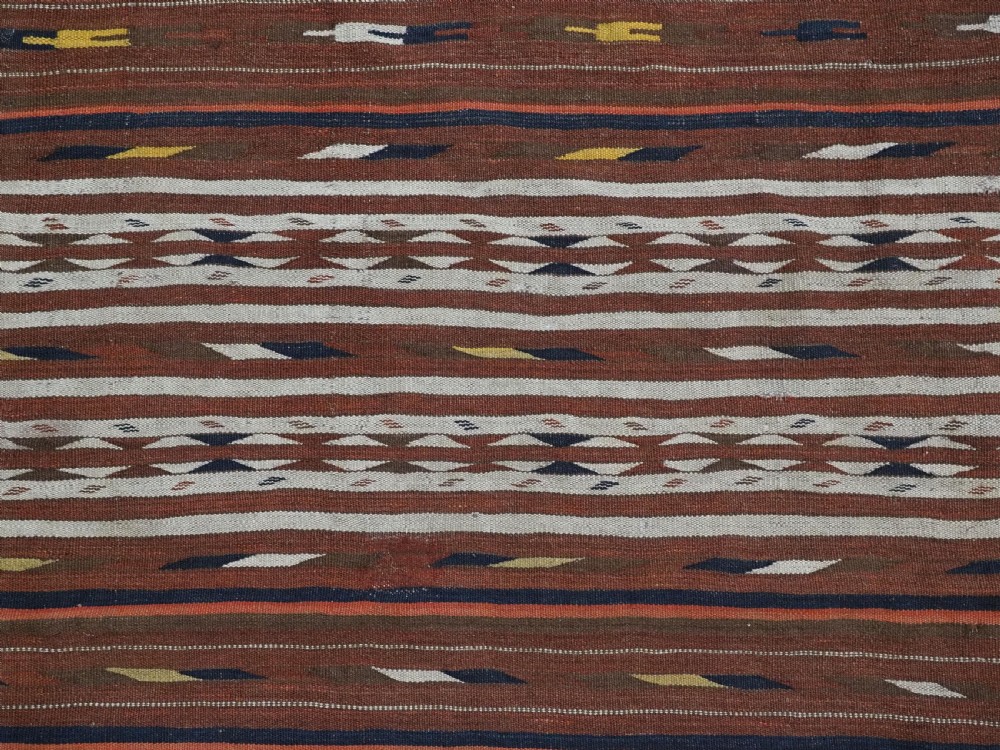 An antique flatweave Turkmen Dali wool kilim rug featuring horizontal bands of terracotta brown, cream, ochre, and dark navy geometric patterns. View VI