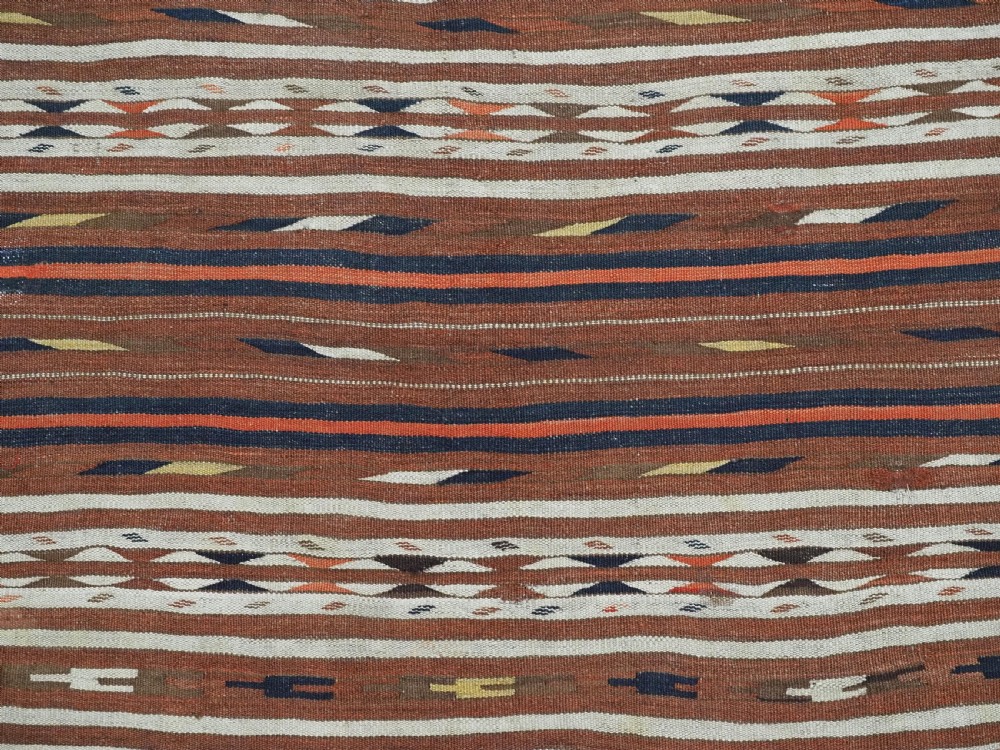 An antique flatweave Turkmen Dali wool kilim rug featuring horizontal bands of terracotta brown, cream, ochre, and dark navy geometric patterns. View VII