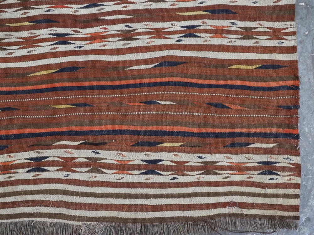 An antique flatweave Turkmen Dali wool kilim rug featuring horizontal bands of terracotta brown, cream, ochre, and dark navy geometric patterns. View VIII
