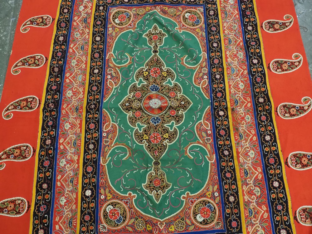 A rectangular antique Persian Rasht embroidery featuring a bright red outer border with boteh motifs surrounding a central green medallion with detailed silk stitching. View V