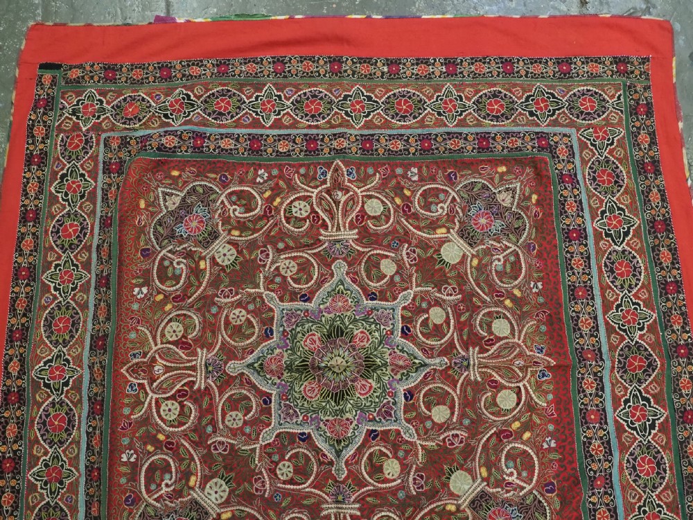 Square antique Persian Rasht embroidery featuring a central green and pink star medallion surrounded by floral motifs on red wool felt with decorative patterned borders. View IV