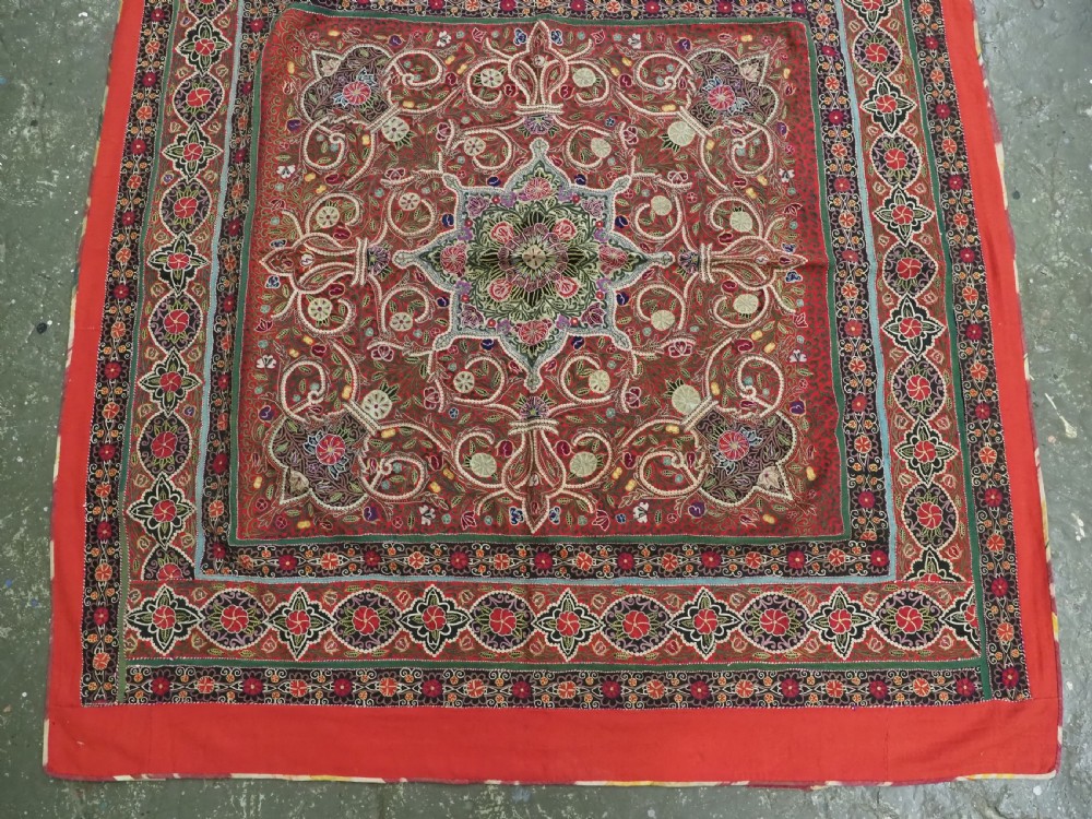 Square antique Persian Rasht embroidery featuring a central green and pink star medallion surrounded by floral motifs on red wool felt with decorative patterned borders. View VI