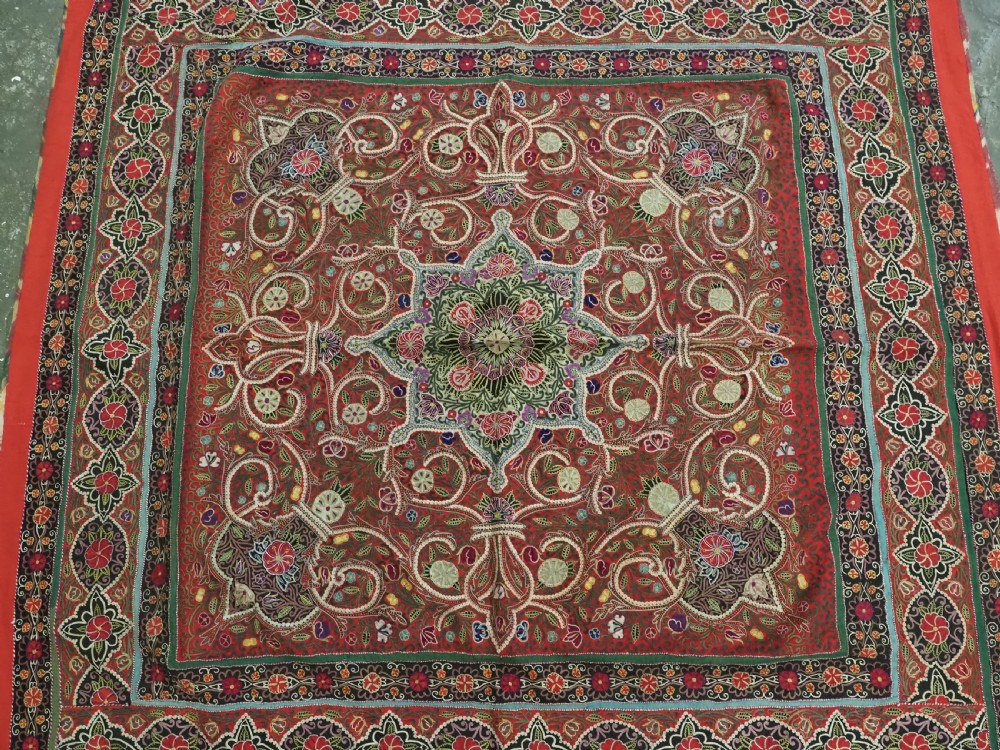 Square antique Persian Rasht embroidery featuring a central green and pink star medallion surrounded by floral motifs on red wool felt with decorative patterned borders. View VII