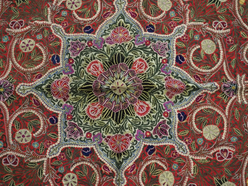 Square antique Persian Rasht embroidery featuring a central green and pink star medallion surrounded by floral motifs on red wool felt with decorative patterned borders. View X