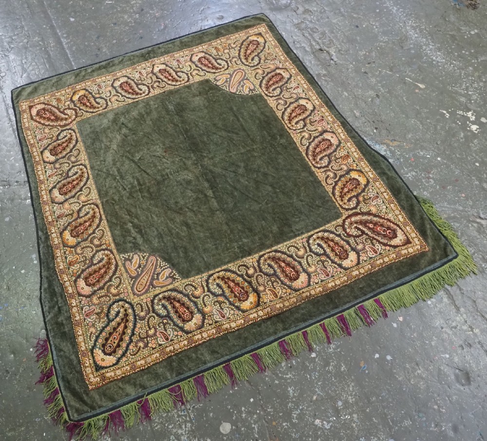 An antique rectangular olive green velvet textile decorated with intricate silk paisley embroidered borders and a fringed edge. View II