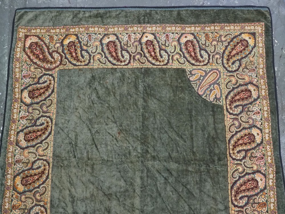 An antique rectangular olive green velvet textile decorated with intricate silk paisley embroidered borders and a fringed edge. View III