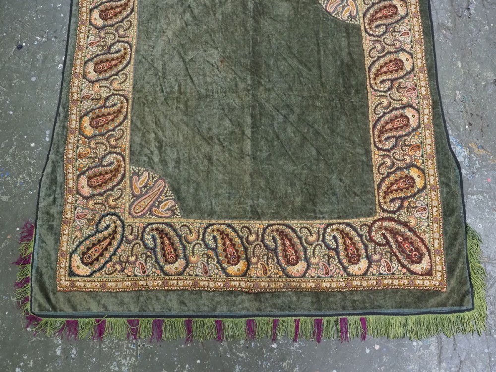 An antique rectangular olive green velvet textile decorated with intricate silk paisley embroidered borders and a fringed edge. View VI