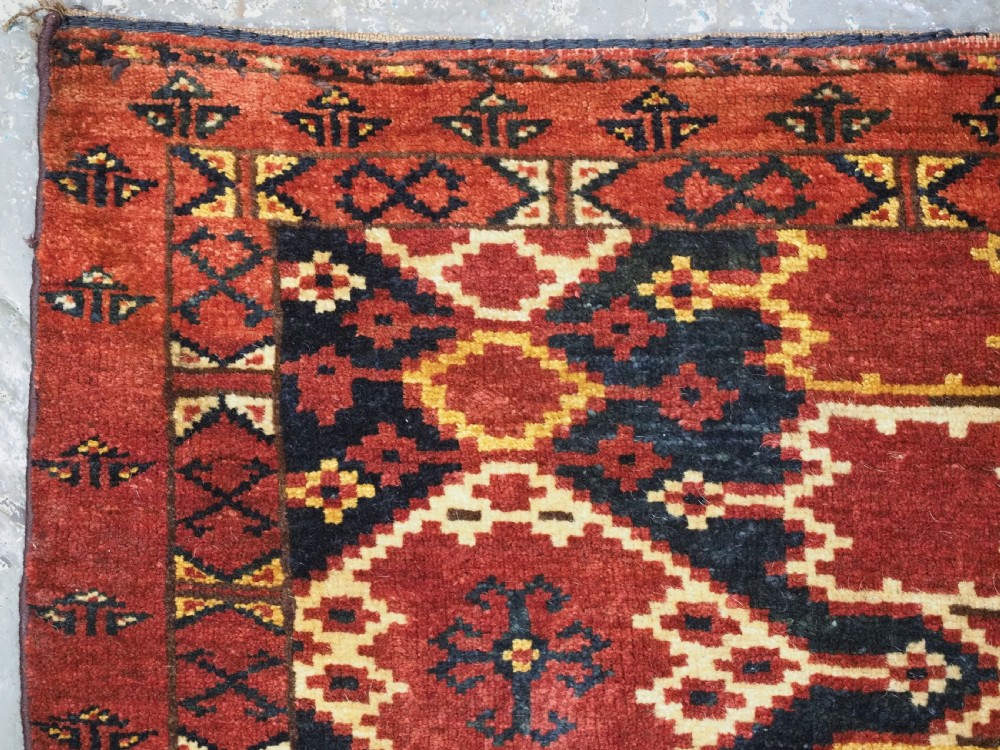 A horizontal rectangular antique Ersari Beshir Turkmen torba textile woven in deep red wool with geometric ikat diamond patterns. View VI
